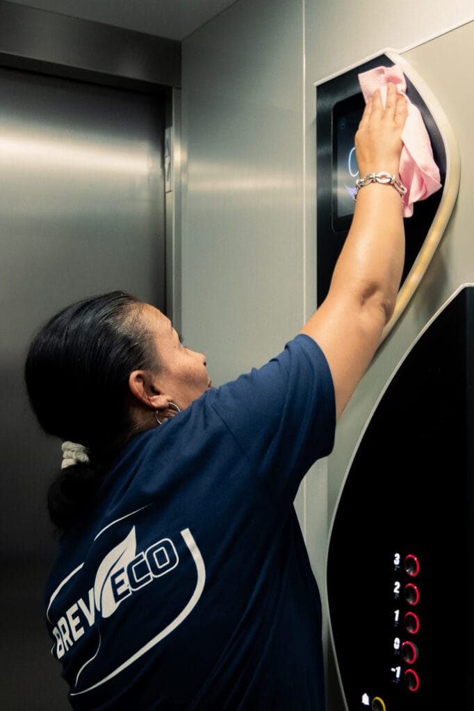 Employer de l'entreprise Breveco, entrain de nettoyer l'ascenseur d'un immeuble de syndic de co propriété